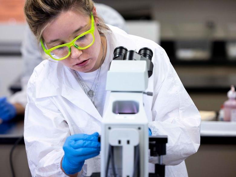 student looking at microscope at Penn State Abington (near Philadelphia)